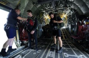 Pararescueman and jump master Senior Master Sgt. Michael Fleming (left) checks the parachute harness of Senior Airman Matt Medlock while Capt. Travis Shepard, a combat rescue officer, awaits a buddy check June 9 before they demonstrate a rigged alternate method zodiac, or RAMZ, capability jump into the Caribbean Ocean for members of the Belize National Coast Guard and local media during Operation Southern Partner. (U.S. Air Force photo/Staff Sgt. Bennie J. Davis III)
