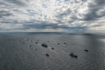 15 mine counter measure ships from 13 nations (Belgium, Denmark, Estonia, Finland, France, Germany, Latvia, Lithuania, Netherlands, Norway, Sweden, United Kingdom, and the United States.) maneuvered in close formation near command ship USS Mount Whitney (LCC 20) for a surface ship Photo Exercise